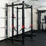 FITEK customisable heavy-duty power rack in a gym setting, featuring red J-hooks and safety straps
