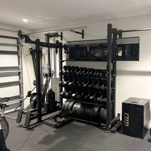 FITEK custom freestanding cable pulley machine with integrated dumbbell and plate storage set up in a compact garage gym