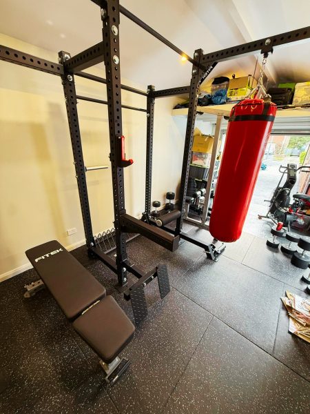 Fully installed FITEK custom garage gym fitout with heavy bag and adjustable bench
